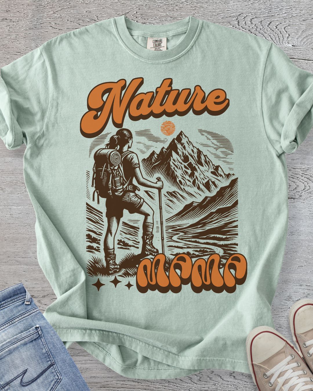 Nature Mama retro hiking t-shirt with female hiker and mountain scene in Comfort Color Bay