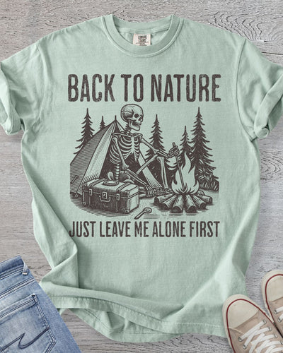 Comfort Colors t-shirt in Bay with skeleton camping graphic and text 'Back to Nature, Just Leave Me Alone First.'